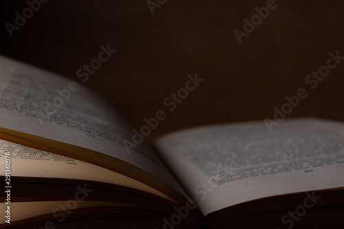 Old book on brown background in the dark close up