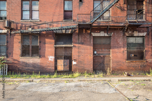 Fototapeta Naklejka Na Ścianę i Meble -  Large metal fire escape on back of a vintage brick building in a small rural town