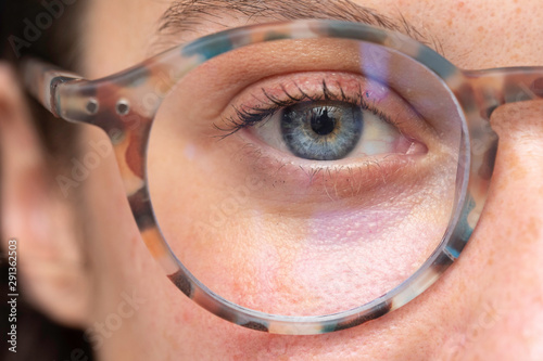 Foto close up on young girl blue eye wearing with corrective lens glasses