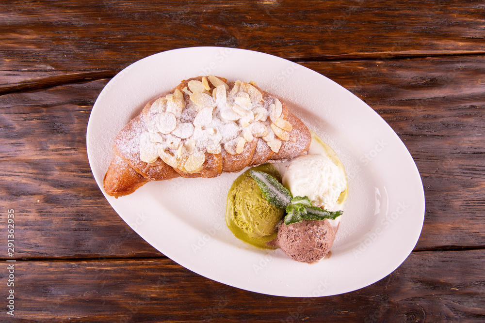 Croissant with almond petals in icing sugar Croissant with almond petals in icing sugar