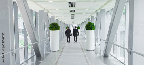 Obraz na płótnie two business men people walking in modern building, vision or success concept w salonie