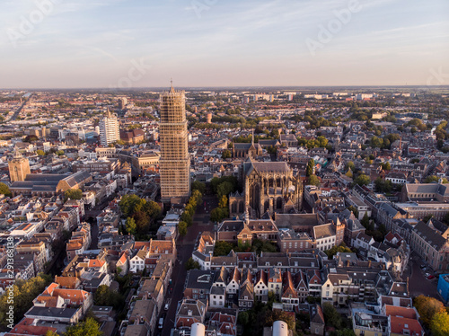 Aerial view of the medieval Dutch city centre of Utrecht with the wrapped church tower of the cathedral towering over the city at early morning sunrise