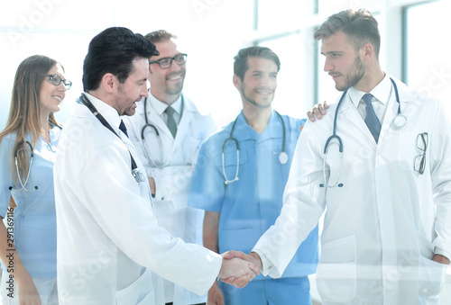 doctors shaking hands in hospital corridor