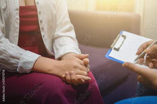 Psychotherapist works and counsels young woman  closeup on hands  toned
