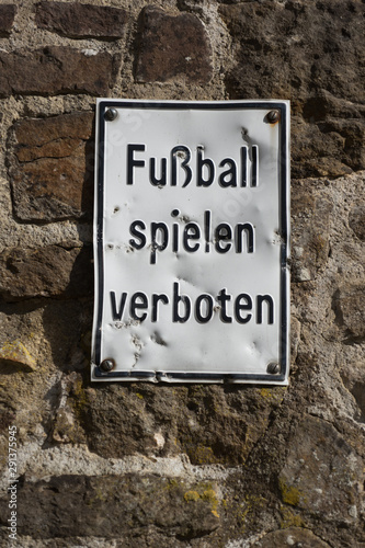 Zerbeultes Schild "Fussball spielen verboten" an der Mauer