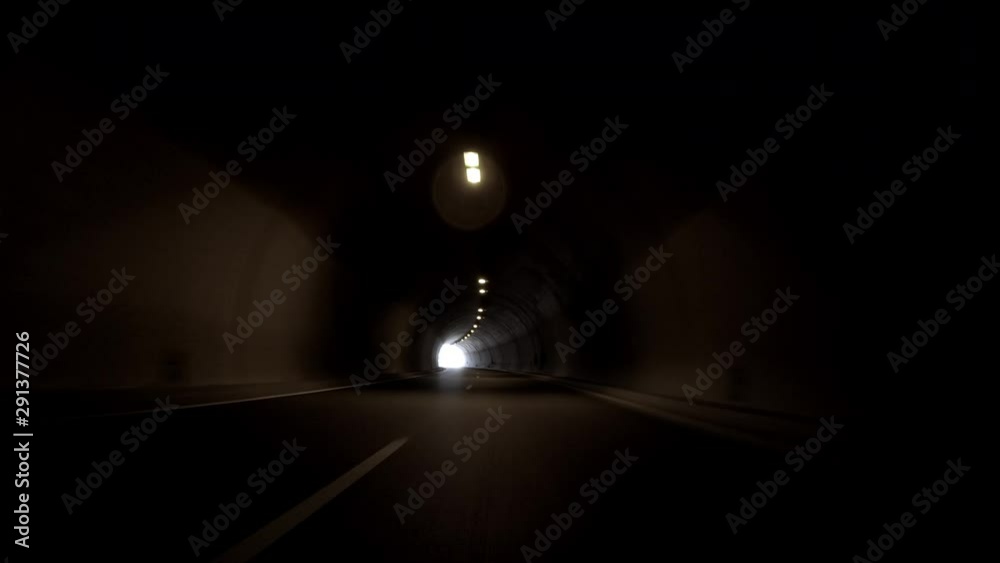 POV, Driving Plate - car driving through a tunnel with bright daylight at the end of it.