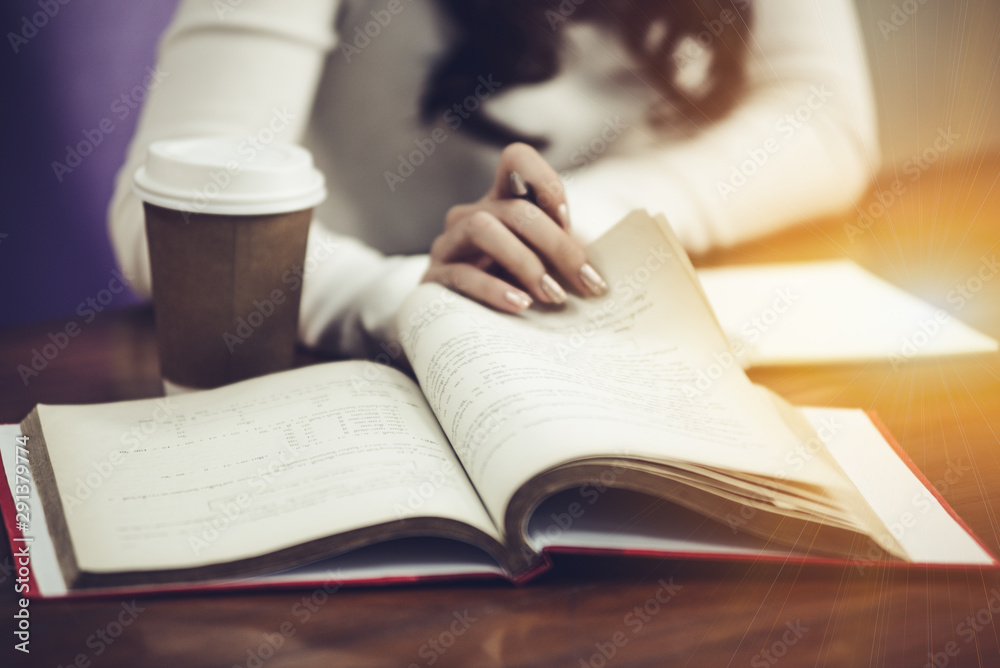 Attractive teenage woman in the library do homework or report to the teachers. Attractive teenage woman in the library do homework or report to the teachers.
