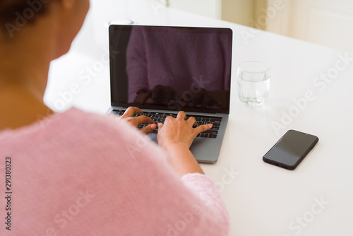 Close up of young woman working typing using laptop