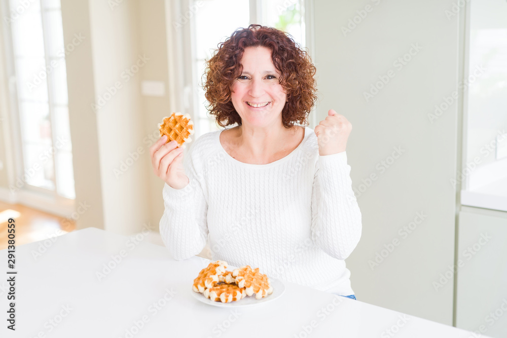 Senior woman eating sweet belgian waffle screaming proud and celebrating victory and success very excited, cheering emotion Senior woman eating sweet belgian waffle screaming proud and celebrating victory and success very excited, cheering emotion