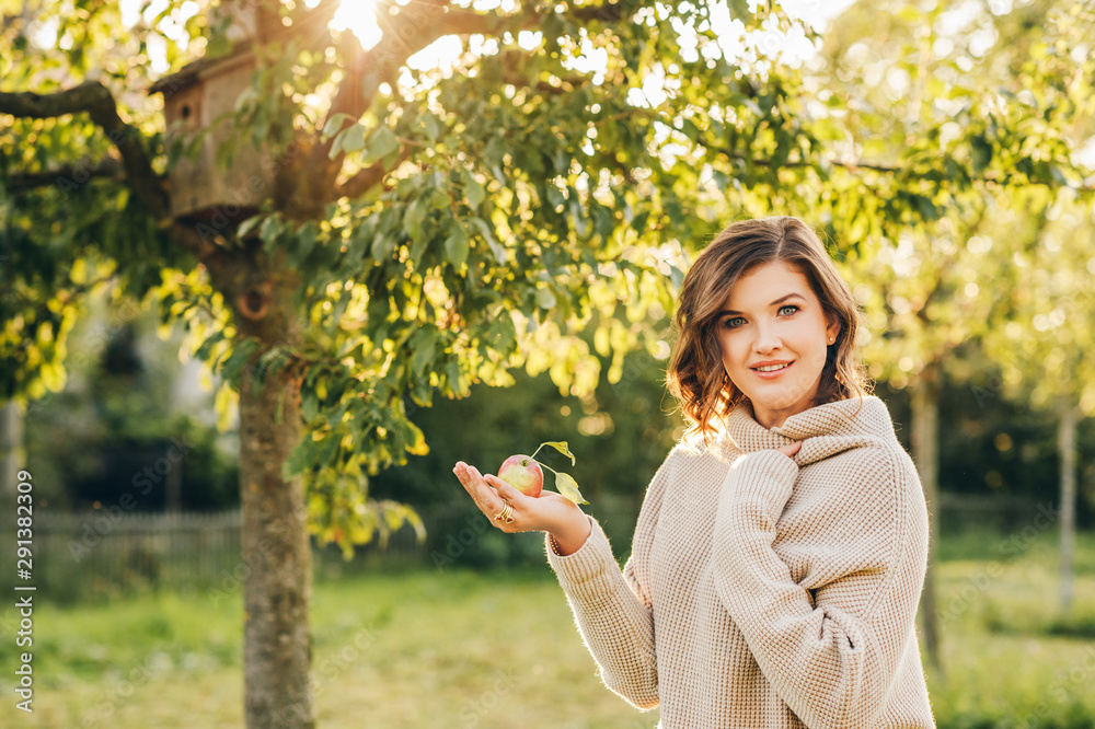 Outdoor portrait of beautiful young woman in the park, wearing warm knitted pullover Outdoor portrait of beautiful young woman in the park, wearing warm knitted pullover