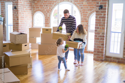 Beautiful famiily with kid moving cardboard boxes at new home photo