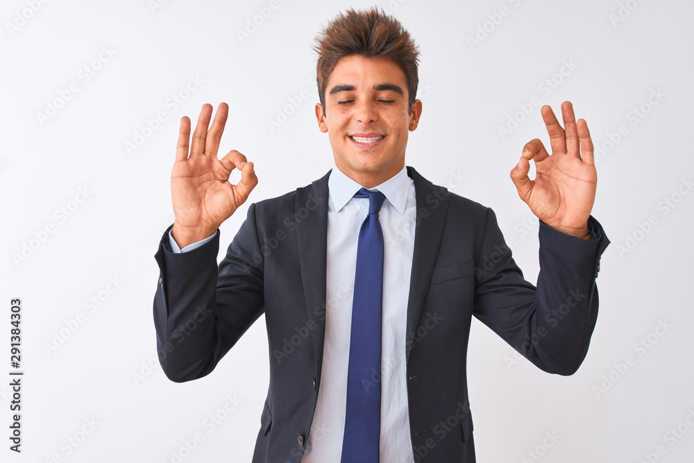 Young handsome businessman wearing suit standing over isolated white background relax and smiling with eyes closed doing meditation gesture with fingers. Yoga concept. Young handsome businessman wearing suit standing over isolated white background relax and smiling with eyes closed doing meditation gesture with fingers. Yoga concept.