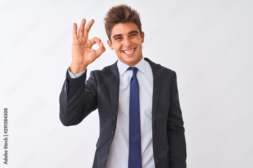 Young handsome businessman wearing suit standing over isolated white background smiling positive doing ok sign with hand and fingers. Successful expression. Young handsome businessman wearing suit standing over isolated white background smiling positive doing ok sign with hand and fingers. Successful expression.