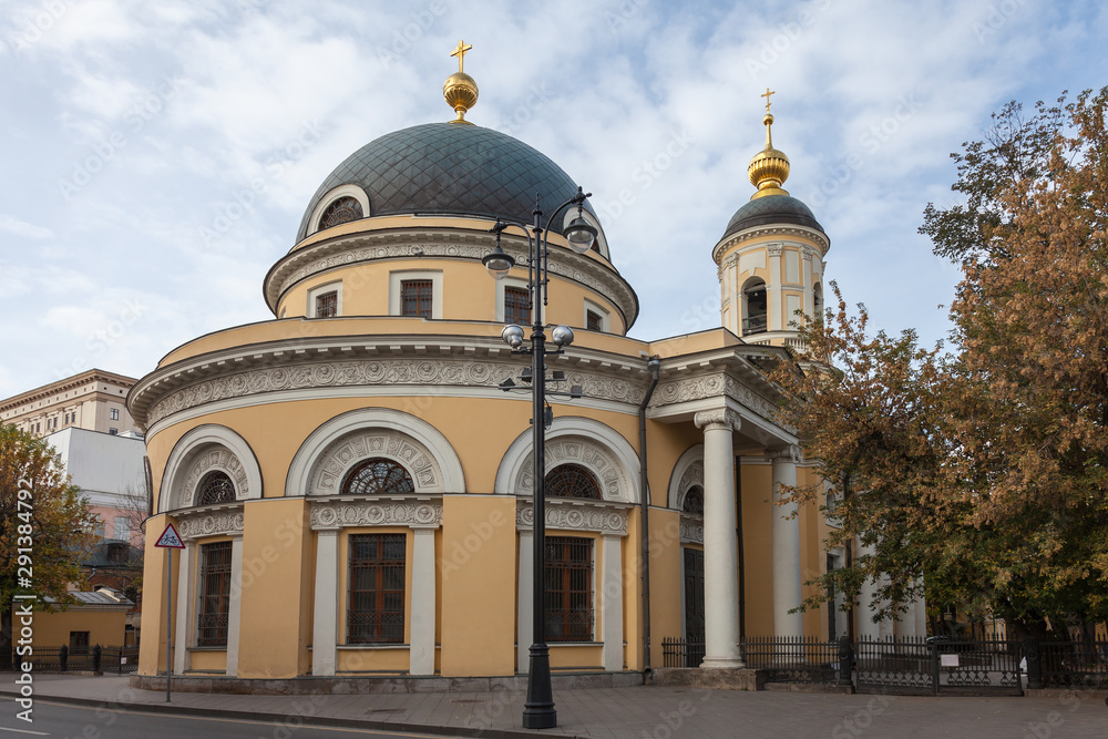 Orthodox church in the center of Moscow with an unusual pattern of facade elements. In the foreground is a street lamp