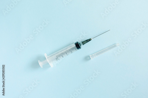 syringe with an open needle on a blue medical background. vaccine, vaccination, medicine for intramuscular and intravenous administration. No Drugs. disease treatment. copy space