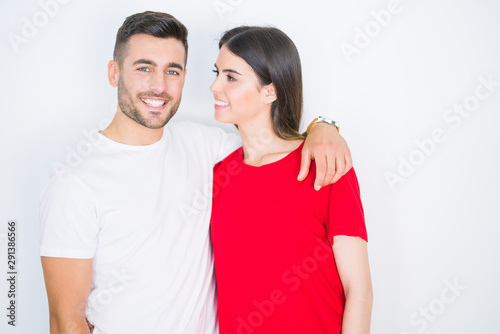 Young beautiful couple in love hugging over white isolated background