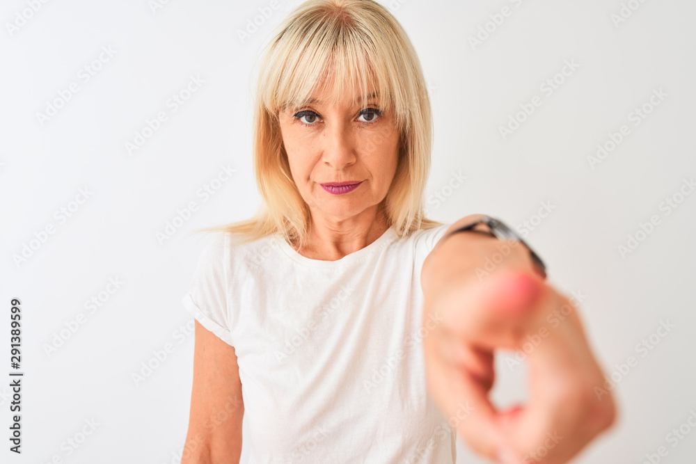 Middle age woman wearing casual t-shirt standing over isolated white background pointing with finger to the camera and to you, hand sign, positive and confident gesture from the front Middle age woman wearing casual t-shirt standing over isolated white background pointing with finger to the camera and to you, hand sign, positive and confident gesture from the front