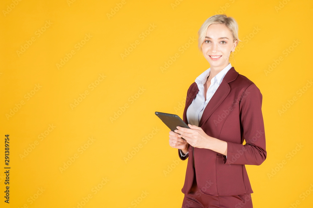 Business woman is using tablet in studio yellow background Business woman is using tablet in studio yellow background