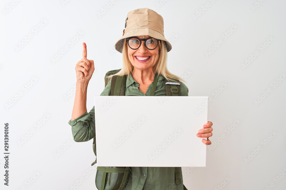 Senior hiker woman wearing canteen hat holding banner over isolated white background surprised with an idea or question pointing finger with happy face, number one Senior hiker woman wearing canteen hat holding banner over isolated white background surprised with an idea or question pointing finger with happy face, number one