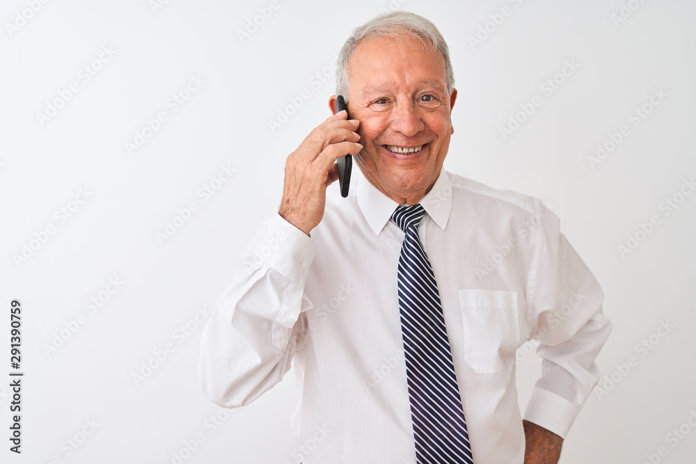 Senior grey-haired businessman talking on the smartphone over isolated white background with a happy face standing and smiling with a confident smile showing teeth Senior grey-haired businessman talking on the smartphone over isolated white background with a happy face standing and smiling with a confident smile showing teeth