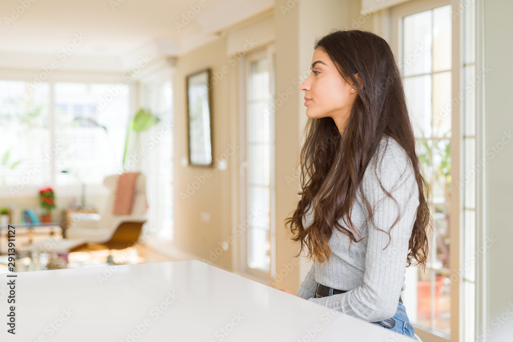 Young beautiful woman at home looking to side, relax profile pose with natural face with confident smile. Young beautiful woman at home looking to side, relax profile pose with natural face with confident smile.