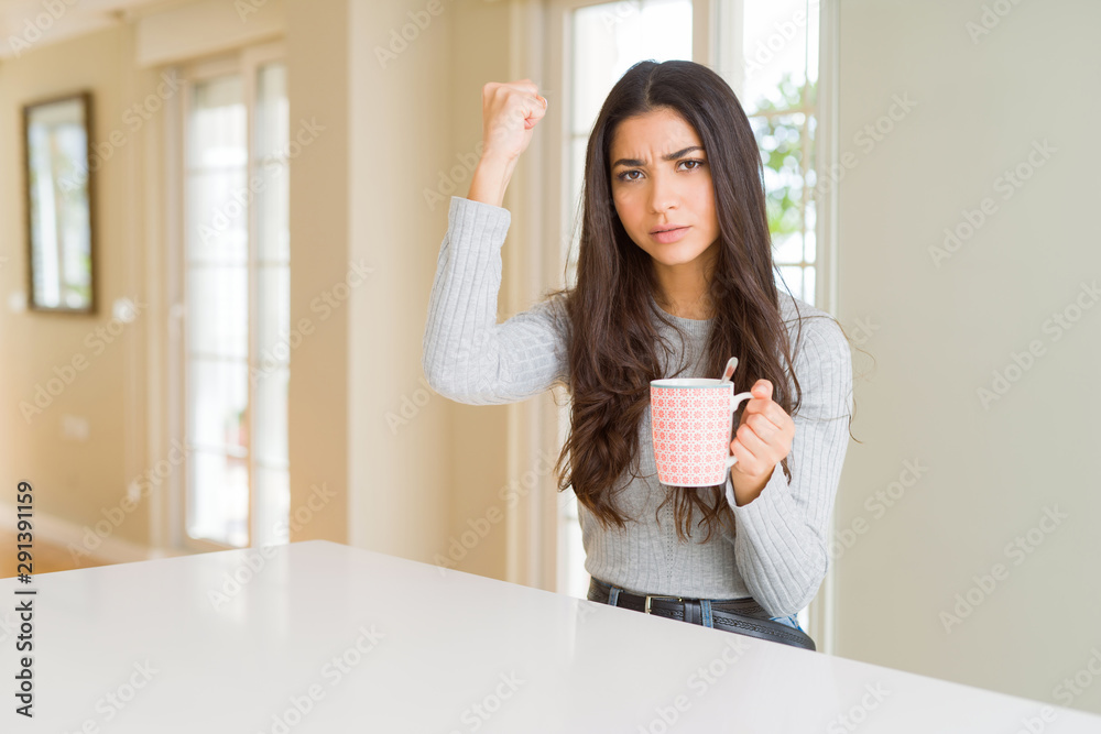 Young woman drinking a cup of coffee annoyed and frustrated shouting with anger, crazy and yelling with raised hand, anger concept Young woman drinking a cup of coffee annoyed and frustrated shouting with anger, crazy and yelling with raised hand, anger concept