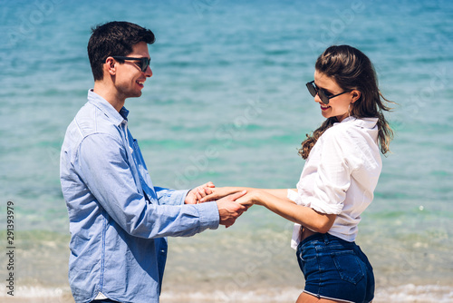 Romantic lovers young couple relaxing together on the tropical beach.Man holding hand with woman and enjoy life.Summer vacations