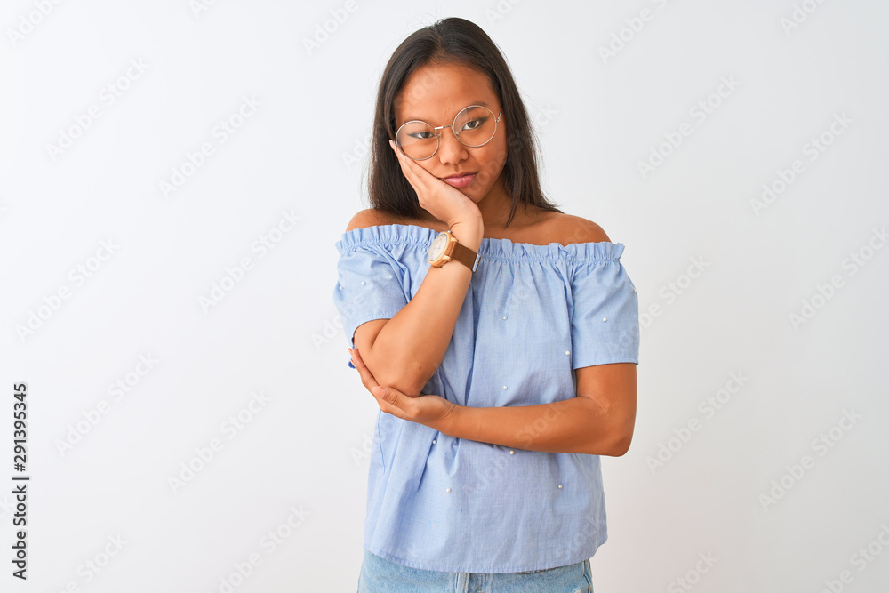Young chinese woman wearing blue t-shirt and glasses over isolated white background thinking looking tired and bored with depression problems with crossed arms. Young chinese woman wearing blue t-shirt and glasses over isolated white background thinking looking tired and bored with depression problems with crossed arms.