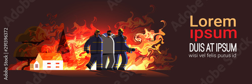 brave firemen couple rescuing injured man from burning house firefighters team in uniform firefighting emergency service extinguishing flame concept flat full length horizontal copy space