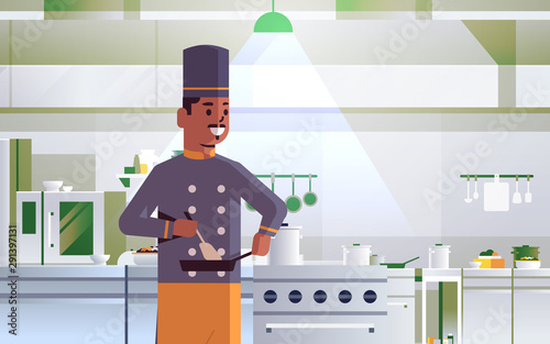 male professional chef using frying pan stirring food african american man in uniform standing near stove cooking concept modern restaurant kitchen interior portrait horizontal