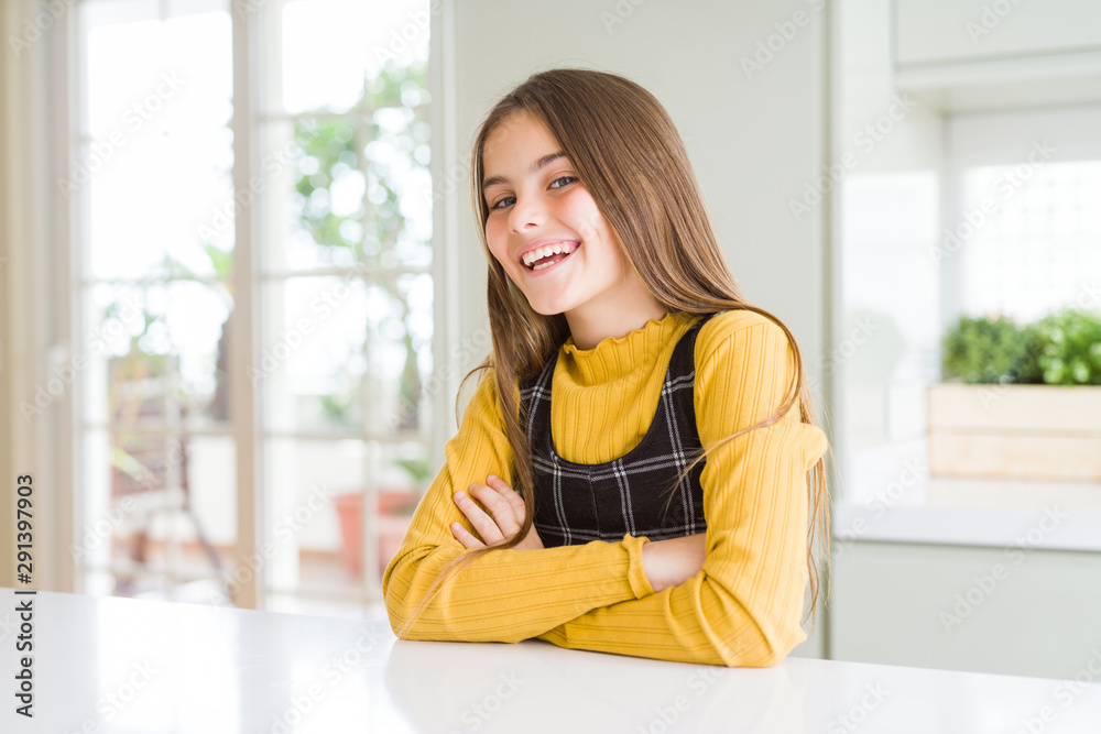 Young beautiful blonde kid girl wearing casual yellow sweater at home happy face smiling with crossed arms looking at the camera. Positive person. Young beautiful blonde kid girl wearing casual yellow sweater at home happy face smiling with crossed arms looking at the camera. Positive person.