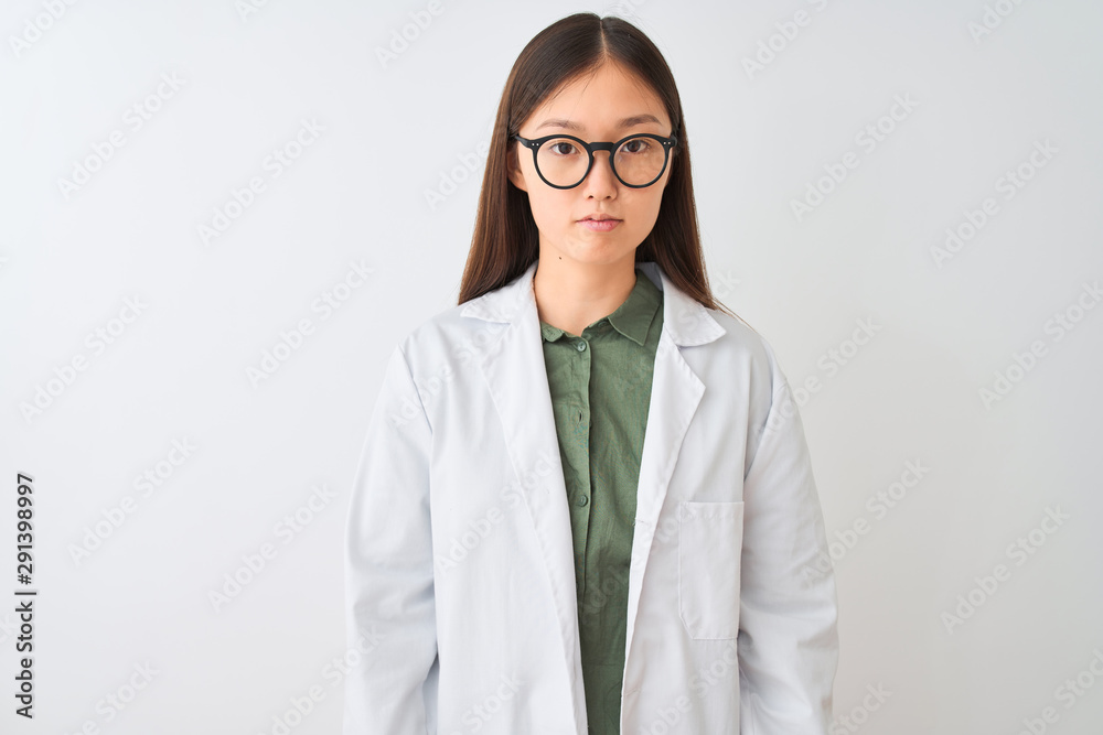 Young chinese scientist woman wearing coat and glasses over isolated white background with serious expression on face. Simple and natural looking at the camera. Young chinese scientist woman wearing coat and glasses over isolated white background with serious expression on face. Simple and natural looking at the camera.