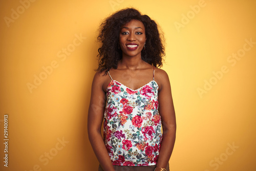 African american woman wearing floral summer t-shirt over isolated yellow background with a happy and cool smile on face. Lucky person.