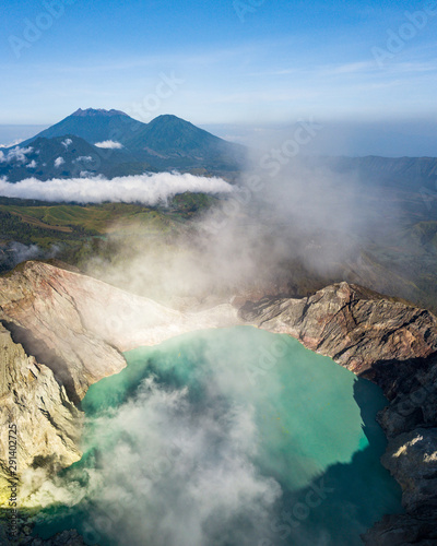 Aerial view of Kawah Ijen at sunrise with mountain background. The most famous tourist attraction in Indonesia. The world's largest acid lake volcano in East Java. The turquoise sulfur lake.