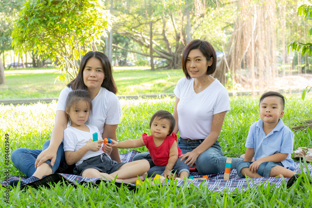 Beautiful young asian parent family portrait picnic in the park, kid or children and mother love happy and cheerful together in summer at garden, lifestyle concept.