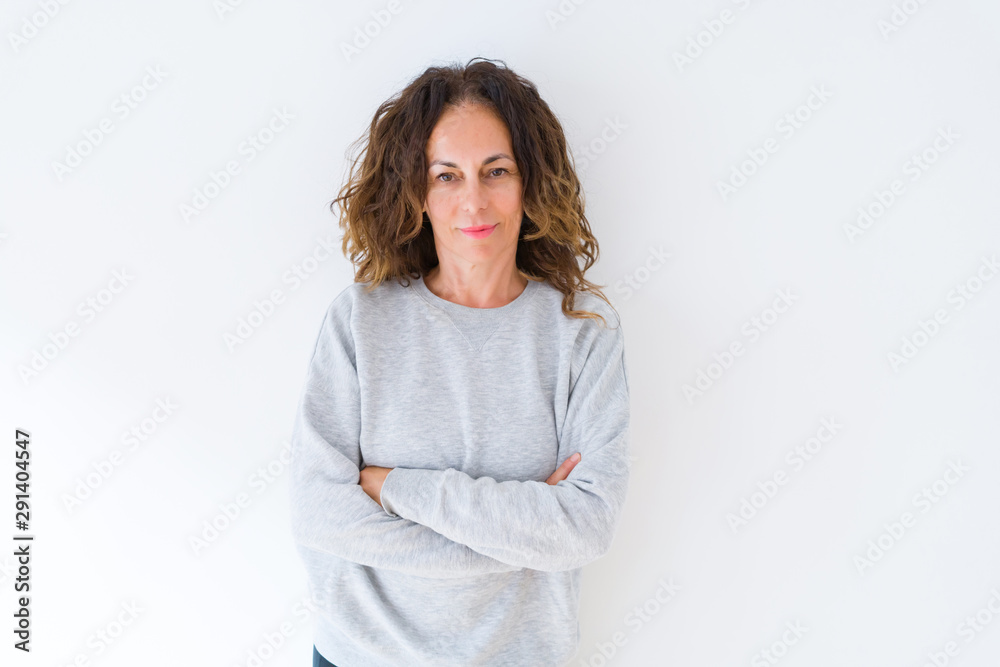 Beautiful middle age woman with curly hair smiling cheerful and happy with arms crossed, laughing with a big smile on face showing teeth over white isolated background Beautiful middle age woman with curly hair smiling cheerful and happy with arms crossed, laughing with a big smile on face showing teeth over white isolated background