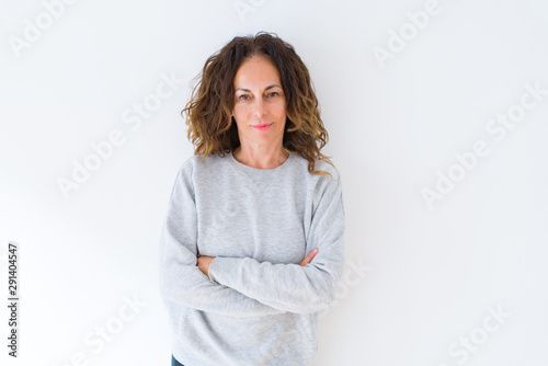 Beautiful middle age woman with curly hair smiling cheerful and happy with arms crossed, laughing with a big smile on face showing teeth over white isolated background