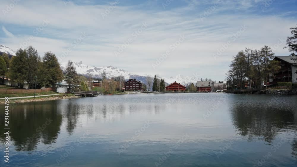 Scenic view of village by the mountain lake. Sunny spring day on Swiss lake. General plan Scenic view of village by the mountain lake. Sunny spring day on Swiss lake. General plan