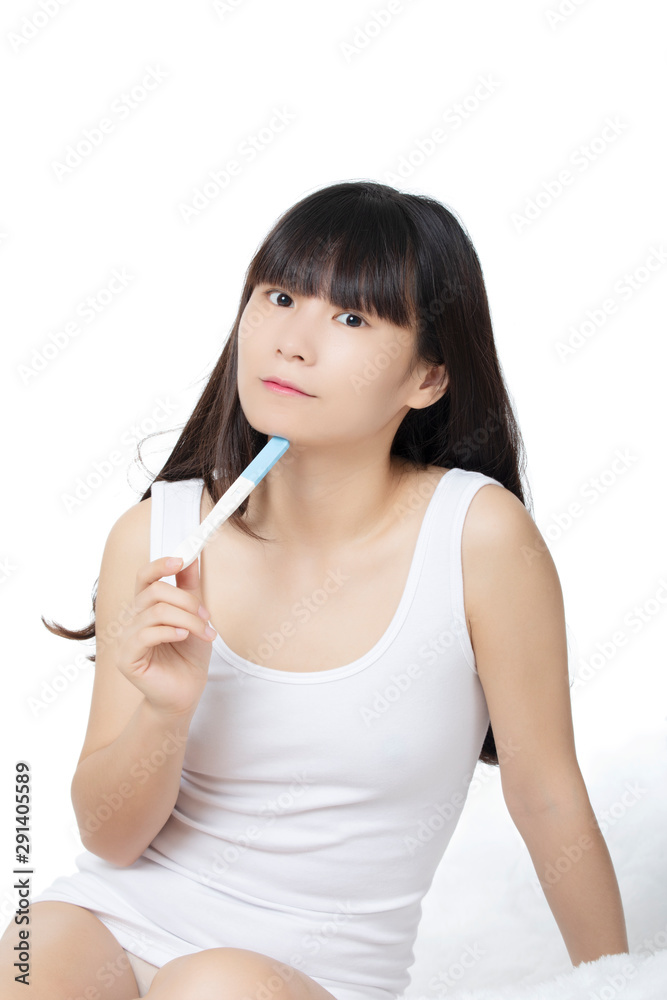 Asian woman holding early pregnancy tester isolated on white background Asian woman holding early pregnancy tester isolated on white background