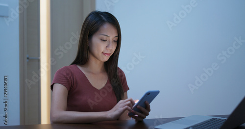 Woman use of mobile phone with laptop computer