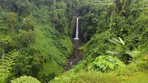 Panning shot of Sopoaga Waterfall in Samoa amongst the lush forest canopy	 photo