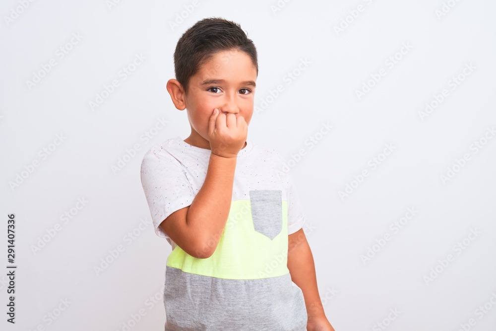 Beautiful kid boy wearing casual t-shirt standing over isolated white background looking stressed and nervous with hands on mouth biting nails. Anxiety problem. Beautiful kid boy wearing casual t-shirt standing over isolated white background looking stressed and nervous with hands on mouth biting nails. Anxiety problem.