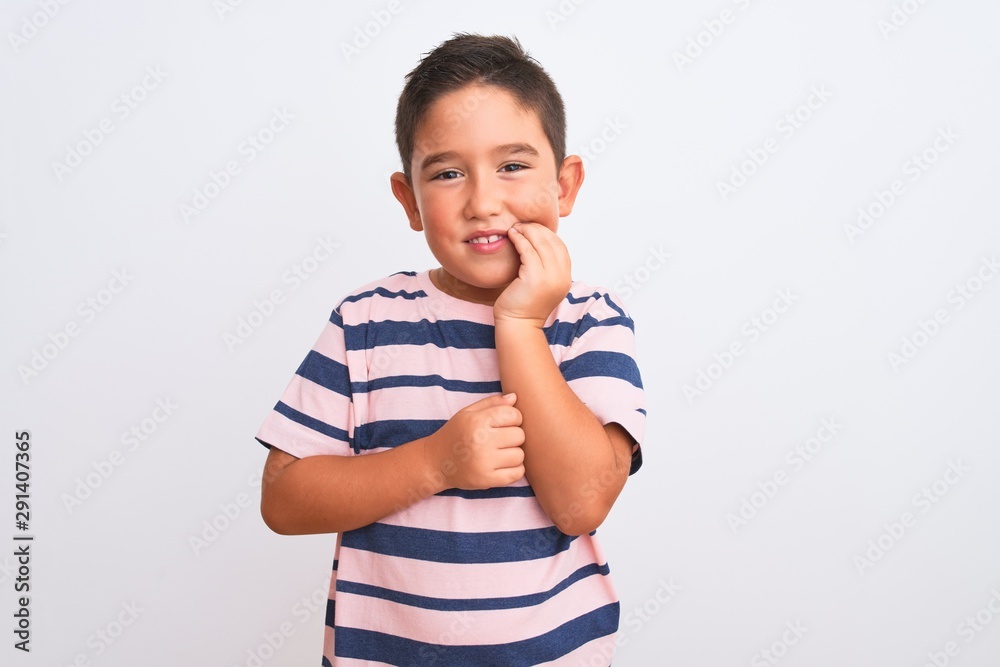Beautiful kid boy wearing casual striped t-shirt standing over isolated white background touching mouth with hand with painful expression because of toothache or dental illness on teeth Beautiful kid boy wearing casual striped t-shirt standing over isolated white background touching mouth with hand with painful expression because of toothache or dental illness on teeth
