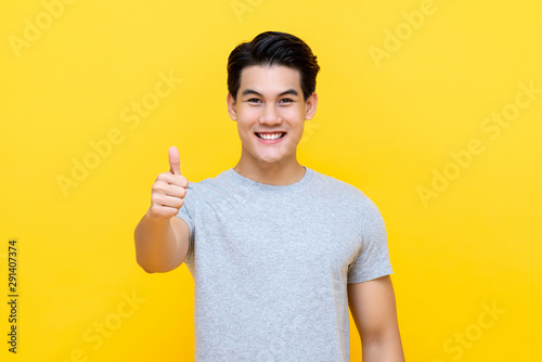 Fotografie Smiling Asian man giving thumbs up