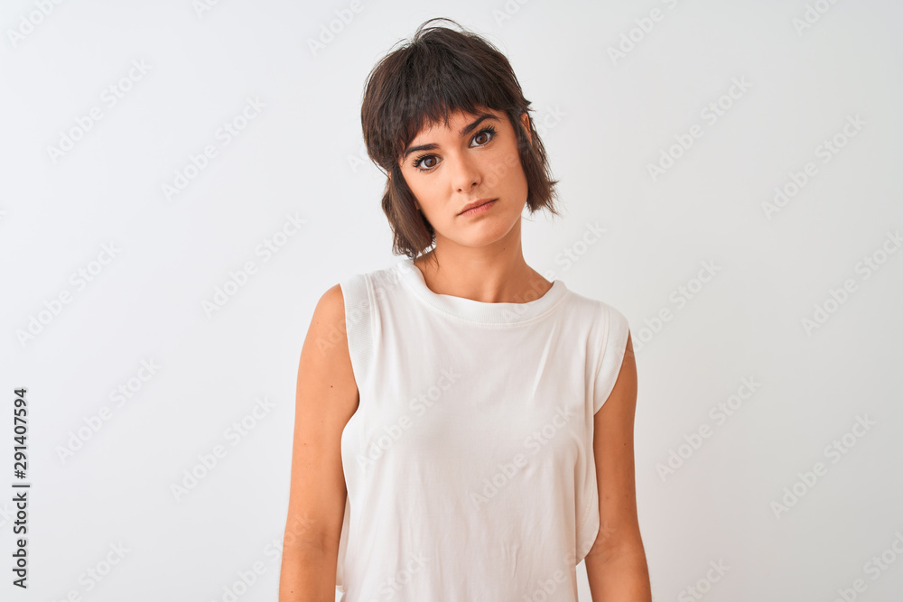 Young beautiful woman wearing casual t-shirt standing over isolated white background with serious expression on face. Simple and natural looking at the camera. Young beautiful woman wearing casual t-shirt standing over isolated white background with serious expression on face. Simple and natural looking at the camera.