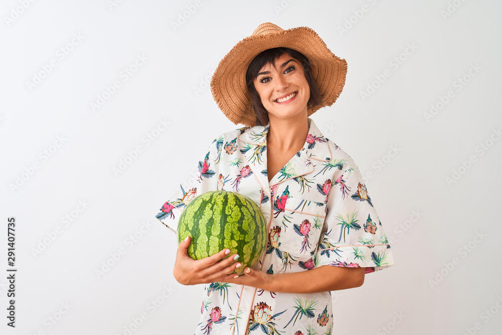 Woman on vacation wearing summer hat holding watermelon over isolated white background with a happy face standing and smiling with a confident smile showing teeth