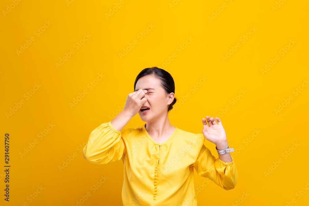 Woman has eyes pain isolated over yellow background Woman has eyes pain isolated over yellow background