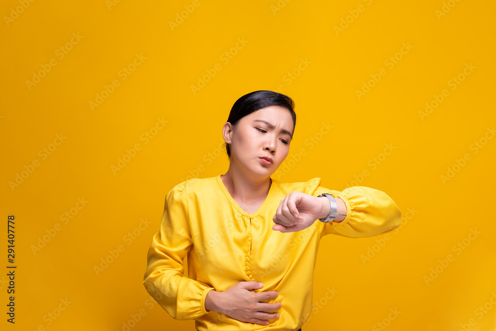Woman has stomach ache isolated over yellow background Woman has stomach ache isolated over yellow background