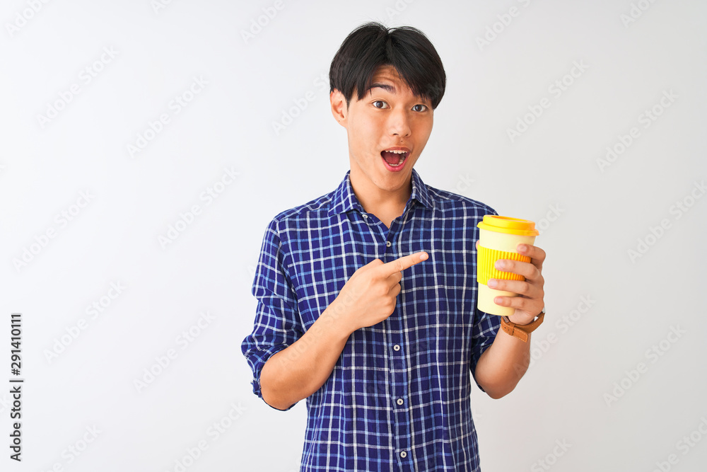 Young chinese man drinking take away coffee standing over isolated white background very happy pointing with hand and finger Young chinese man drinking take away coffee standing over isolated white background very happy pointing with hand and finger