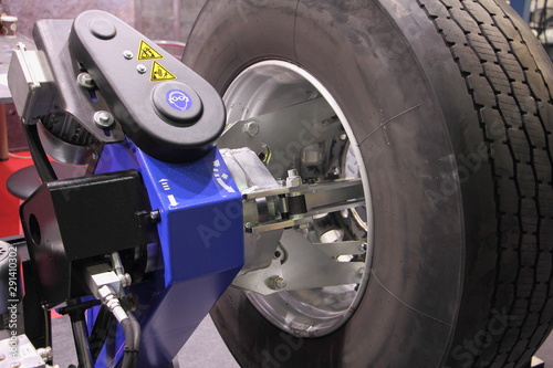 Obraz na płótnie Truck wheel balance equipment, close up big vehicle tyre on balancing stand w salonie